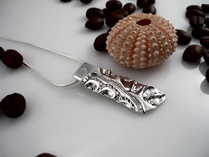 ELONGATED LAND AND SEA, sterling silver pendant with a sea urchin shell and coffee bean imprint!