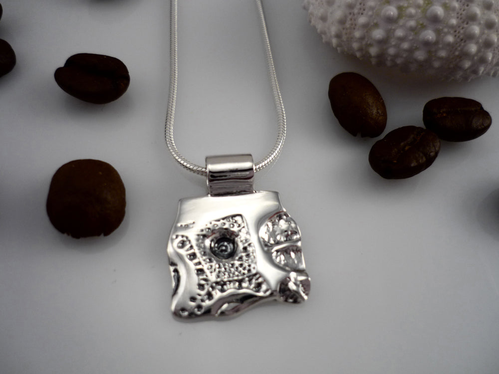 LAND AND SEA SMALL, sterling silver pendant with a sea urchin shell and coffee bean imprint!